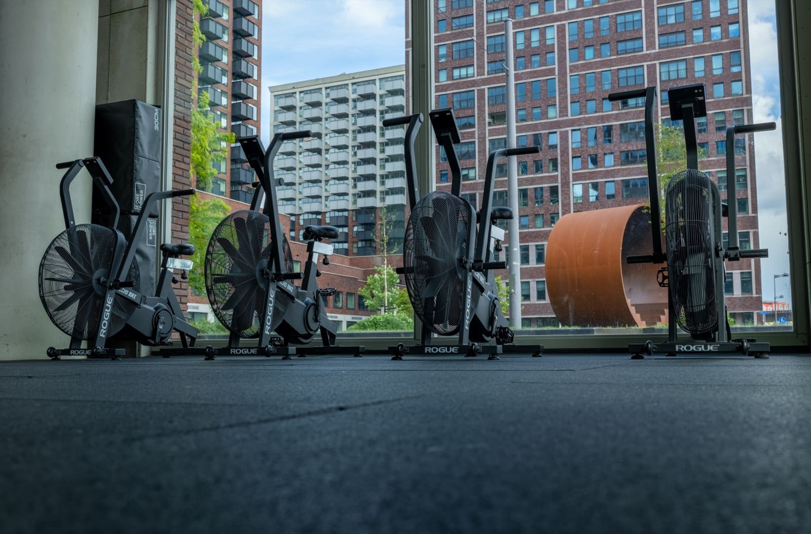 Rij Echo bikes voor de hoge ramen met uitzicht op de stad bij Body Matrix Rotterdam